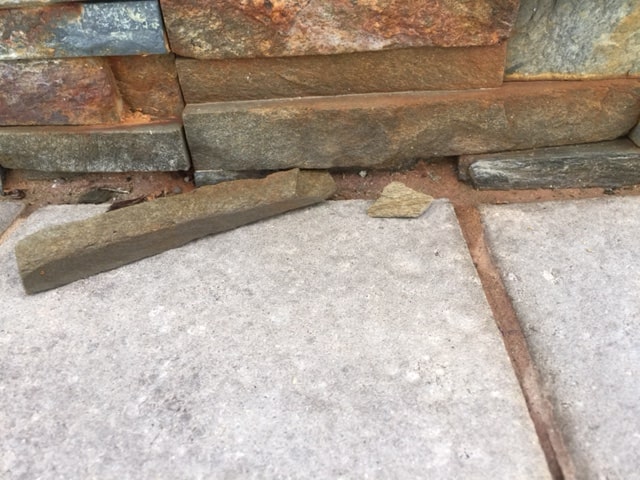 Small piece of stone has spalled or fallen off from a natural stacked stone wall